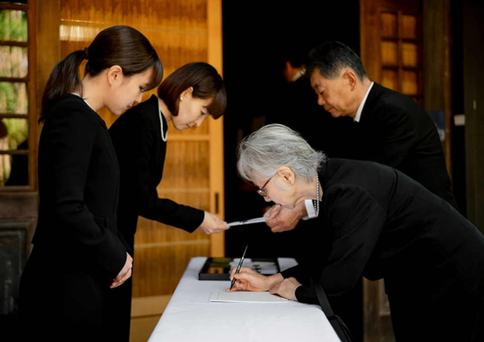 家族葬メモサが足立区で通夜受付を行う遺族と受付係の様子、二日家族葬プラン案内