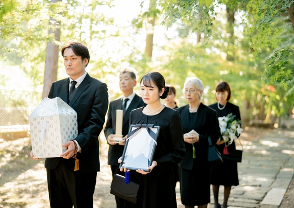 家族葬メモサが足立区で二日家族葬の遺影と骨箱を手向ける参列者を案内している
